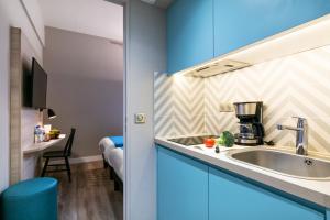 a kitchen with blue cabinets and a sink at Appart'City Confort Montpellier Saint Roch in Montpellier
