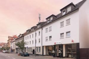 eine Reihe weißer Gebäude in einer Stadtstraße in der Unterkunft Novum Hotel Bruy in Stuttgart