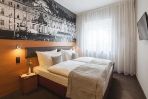 シュトゥットガルトにあるNovum Hotel Bruyのベッドルーム(大型ベッド1台、窓付)