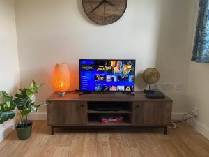 a flat screen tv sitting on top of a wooden entertainment center at Peak House in Ilkeston