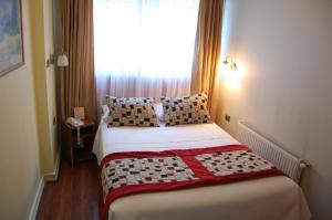 a small bedroom with a bed with a window at Hotel Plaza Concepción in Concepción