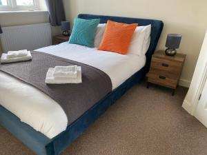 uma cama com almofadas coloridas num quarto em Peak House em Ilkeston