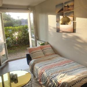 a bedroom with a bed and a table and a window at Appartement Toulouse Blagnac MEET Aéroport 5 min Tramway à 6 min free Parking Proche de toutes commodités Belle terrasse in Blagnac