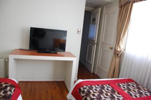 a room with a flat screen tv on a table at Hotel Plaza Concepción in Concepción