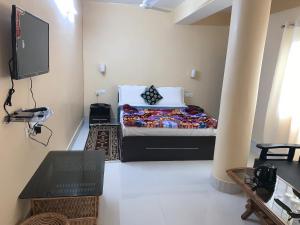 a small room with a bed and a tv at Hotel Cymbidium Residency in Tādong