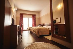a hotel room with two beds and a television at Hotel Vila Emei in Maribor