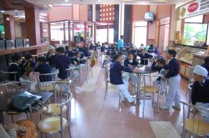 a group of children sitting at tables in a restaurant at Savoy Greens Karnal in Karnal