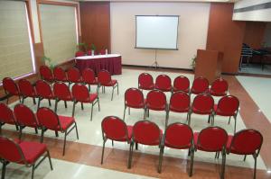 una sala de conferencias con sillas rojas y una pantalla en Savoy Greens Karnal en Karnal