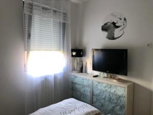 een slaapkamer met een flatscreen-tv en een raam bij Apartment Sweet Dreams-Maksimir Ravnice-ZOO-free parking in Zagreb