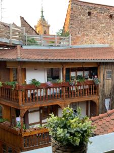 a wooden house with a balcony and two potted plants at Coquet Studio Colmar Centre in Colmar