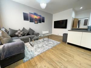 sala de estar con sofá y TV de pantalla plana en Exquisite 2BR Flat near Central Train Station, en Glasgow