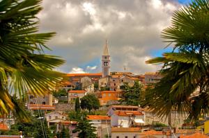 a city with a clock tower on a hill at Apartments Sandra in Vrsar