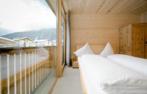 Habitación de madera con 2 camas y ventana en Ferienhaus Alpin, en Neustift im Stubaital