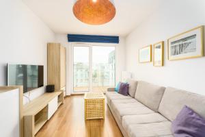 un soggiorno con un divano e una TV di APT Nadmorskie - Solne a Kołobrzeg