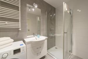 un bagno bianco con doccia e lavandino di APT Nadmorskie - Solne a Kołobrzeg Altre 28 foto