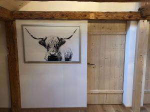a picture of a cow with horns on a wall at Chalet Schwendli in Schwarzsee