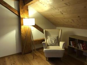 a living room with a chair and a lamp at Chalet Schwendli in Schwarzsee