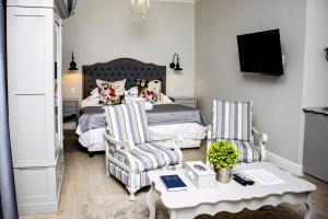 a bedroom with a bed and two chairs and a table at French Karoo Guesthouse in Beaufort West