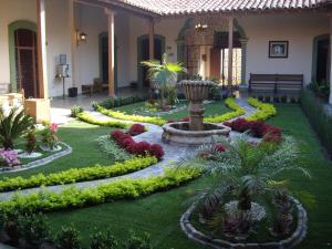 un jardín con una fuente en medio de un patio en Hotel La Merced en Colima