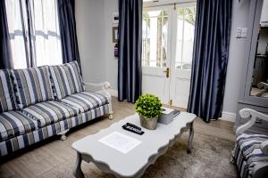 un soggiorno con divano e tavolo di French Karoo Guesthouse a Beaufort West
