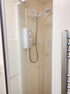 a shower with a shower head in a bathroom at Glasgow City Centre Studio Apartment in Glasgow