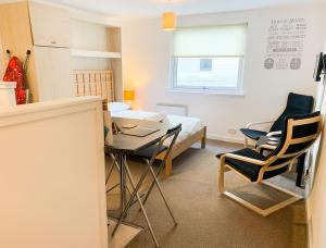 Cette chambre comprend un lit, une table et des chaises. dans l'établissement Glasgow City Centre Studio Apartment, à Glasgow