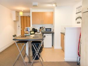 a small kitchen with a table and a microwave at Glasgow City Centre Studio Apartment in Glasgow