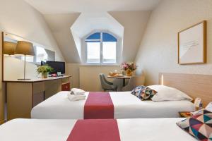 um quarto de hotel com duas camas e uma mesa em Appart'City Classic Nantes Viarme em Nantes