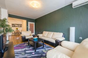 a living room with white furniture and a green wall at Sofia Central Hotel Apartments in Sofia +28 photos