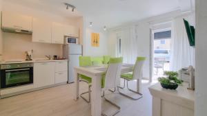 a kitchen with a table and green chairs in it at Sebastian in Novigrad Istria +15 photos
