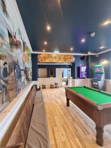 a billiard room with a pool table and a arcade at Y Griffin in Penrhyndeudreath