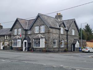 an old stone house on the corner of a street at Y Griffin in Penrhyndeudreath