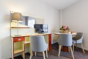 a room with a desk with two chairs and a computer at Appart'City Classic Nantes Viarme in Nantes