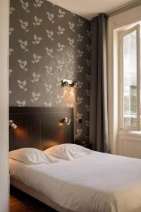 een slaapkamer met een bed en een muur met bloemen bij Le Napoleon in Lille