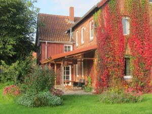 a building covered in ivy with flowers on it at Historisches Ferienhaus Zum alten Standesamt in Weenzen