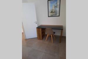 a desk with a chair next to a table at SUPERBE VILLA 85 m2 NIMES CAREMEAU in Nîmes