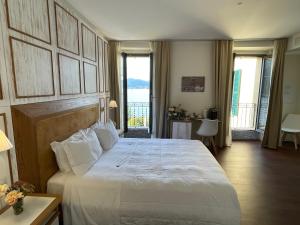 a bedroom with a large white bed and a balcony at Il Belvedere in Torno
