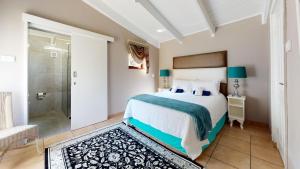 ein Schlafzimmer mit einem Bett und einer ebenerdigen Dusche in der Unterkunft San Lameer Villa 2910 by Top Destinations Rentals in Southbroom