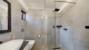 a bathroom with a shower and a toilet and a sink at San Lameer Villa 2910 by Top Destinations Rentals in Southbroom