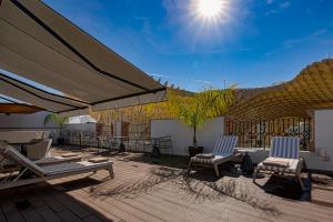 un patio con sedie e ombrelloni su una terrazza di Intelier Casa de Indias a Siviglia