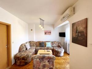 a living room with a couch and two chairs at Apartments Bohovic in Šilo