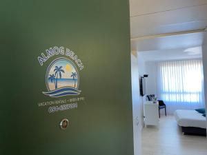 um quarto com uma placa de hotel na parede em Almog Beach Apartments מגדלי חוף הכרמל חיפה em Haifa