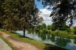 a river with trees and a path next to it at Apartman MIMA in Karlovac