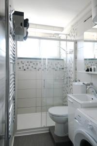 a white bathroom with a toilet and a sink at Apartman MIMA in Karlovac