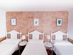 1 dormitorio con 2 camas y 2 mesas en El Nogal Home en Málaga