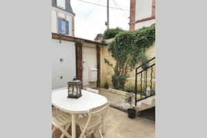 a white table and chairs in front of a building at Les etapes chartraines parking wifi jaccuzi in Chartres