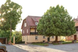 ein großes Haus mit einem Baum davor in der Unterkunft Rittergut Hirschbach - Verwalterhaus in Hirschbach