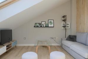 a white living room with a couch and a table at La Plaza-Atico in Villafranca de los Barros