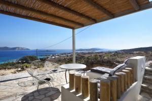 a patio with a table and chairs and the ocean at Koufonisi Villas in Koufonisia