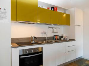 una cocina con armarios blancos y fregadero en Apartment Cjase dai Fornasirs by Interhome en Raveo